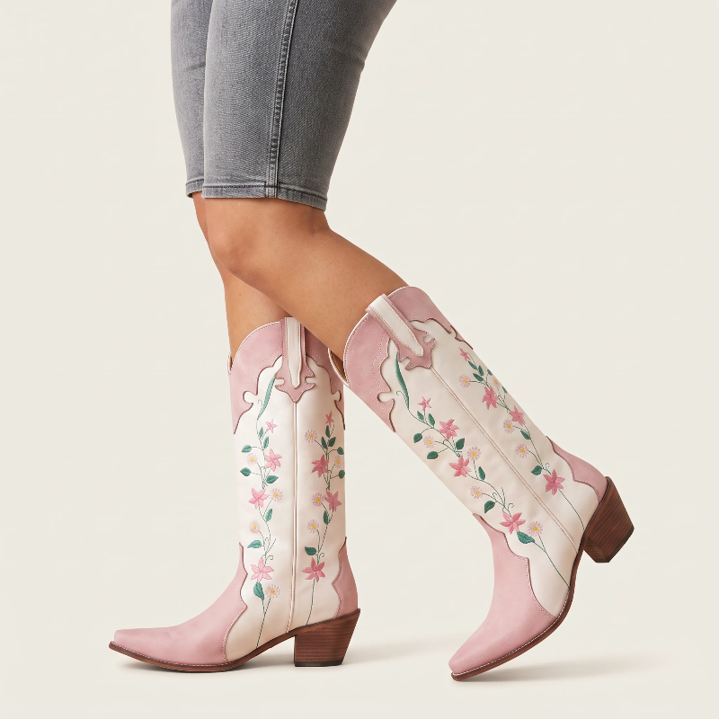 Yehaw knee-high vegan leather cowgirl boots in white and pink with floral embroidery and a pointed toe.