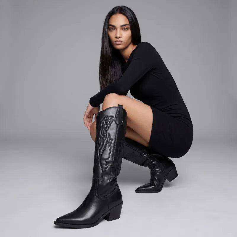Yehaw black vegan leather knee-high cowgirl boots with pointed toe and medium heel. Zip fastening.