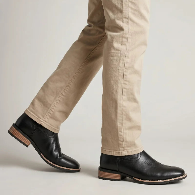 Yehaw BILLY men's black vegan leather cowboy boots with a round toe and low heel worn with beige trousers.