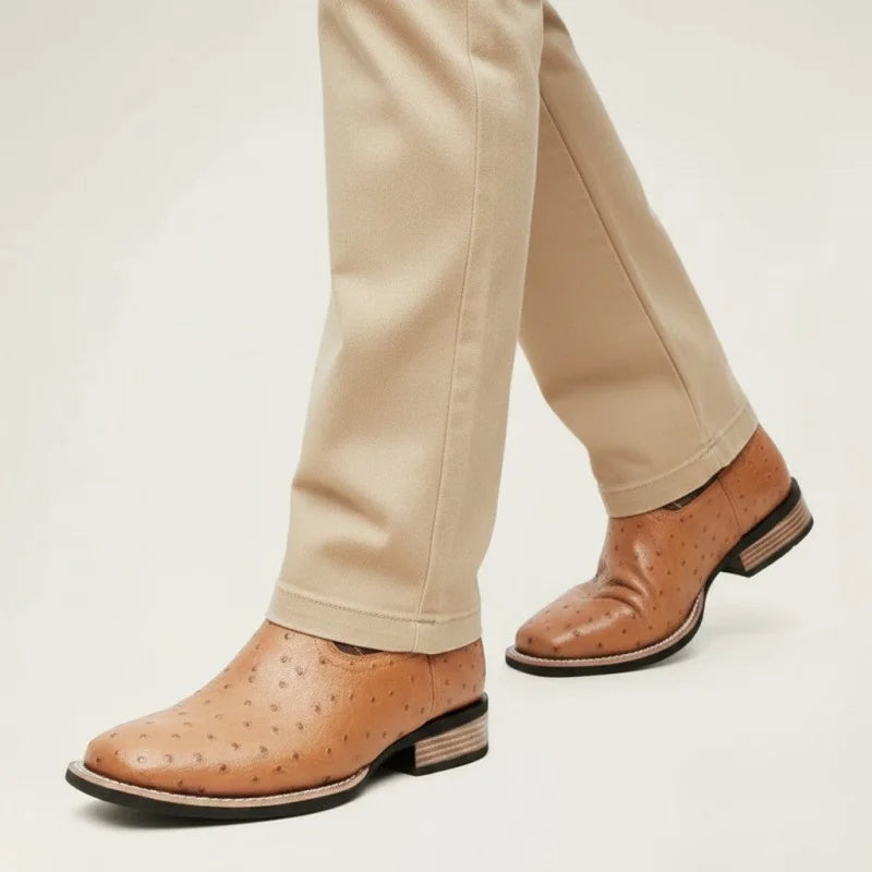 Yehaw brown vegan leather cowboy boots with a textured finish and round toe, worn with beige trousers.
