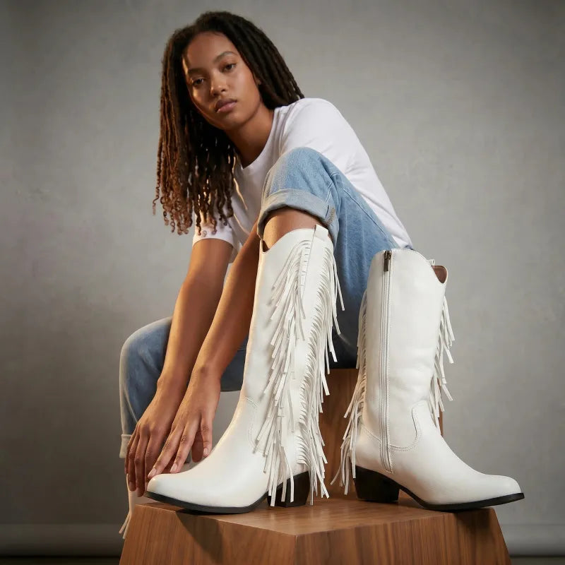 Yehaw white vegan leather knee-high cowgirl boots with fringe detailing and a square toe.