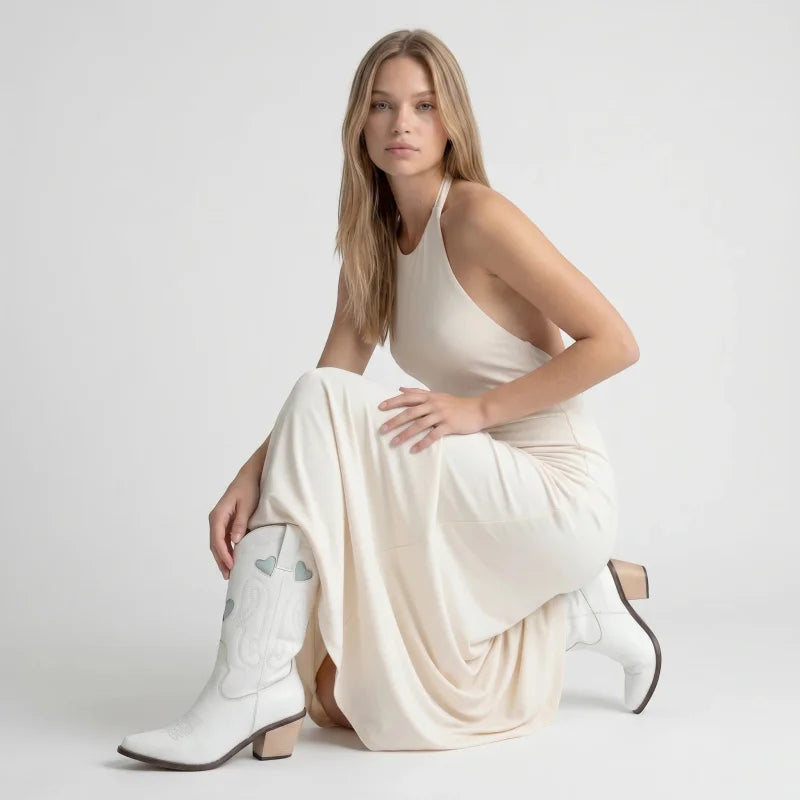 Model wearing Yehaw white vegan leather mid-calf cowgirl boots with pointed toe and high heel in a studio setting