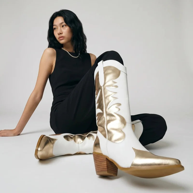 Model wearing Yehaw white and gold vegan leather mid-calf cowgirl boots with western stitching and a medium heel.