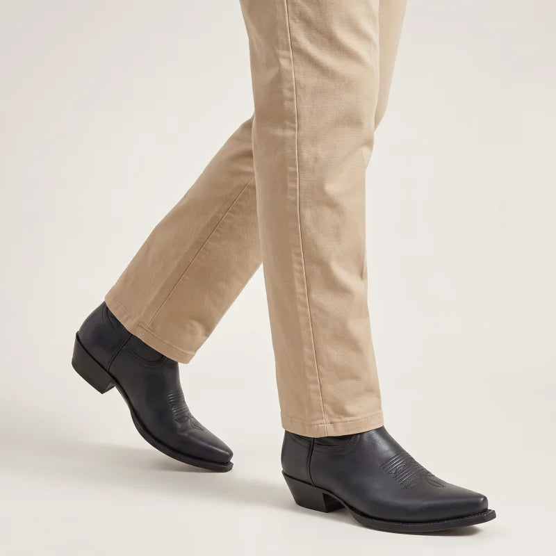 Yehaw TEDDY black vegan leather cowboy boots for men with a pointed toe and low heel, worn with beige trousers.