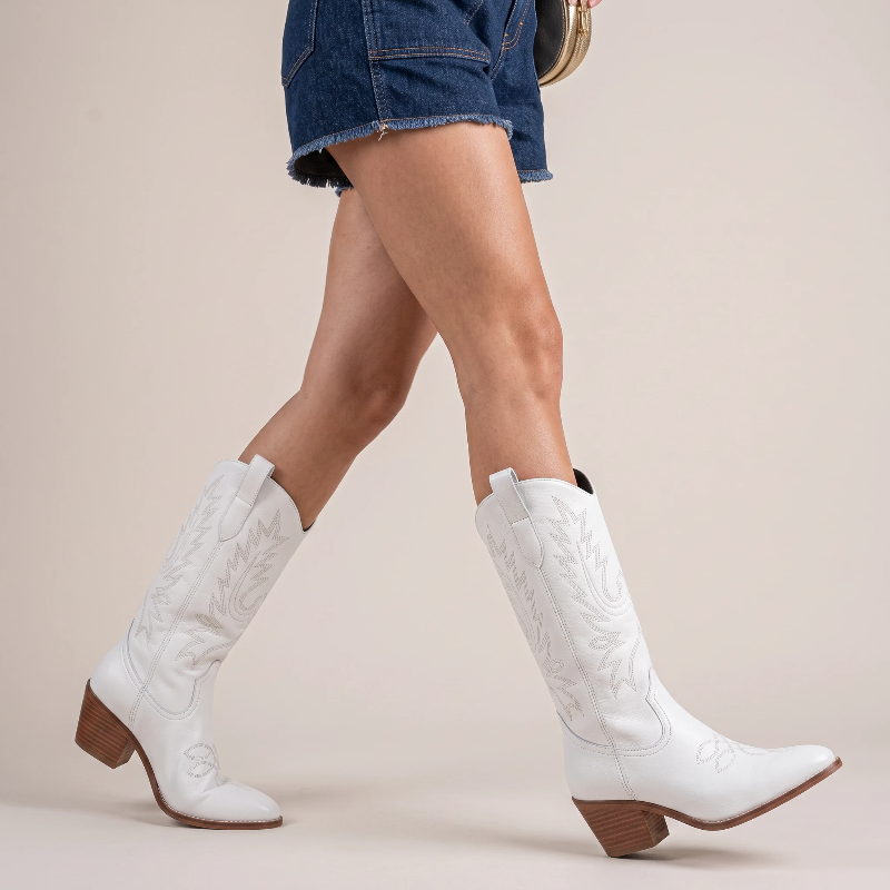 Yehaw white vegan leather mid-calf cowgirl boots with pointed toe and western stitching worn by a woman