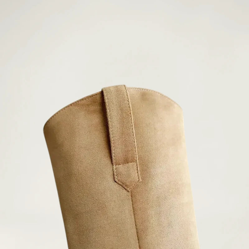 Yehaw beige vegan suede knee-high cowgirl boots with a pointed toe and side zip worn by a woman in denim shorts