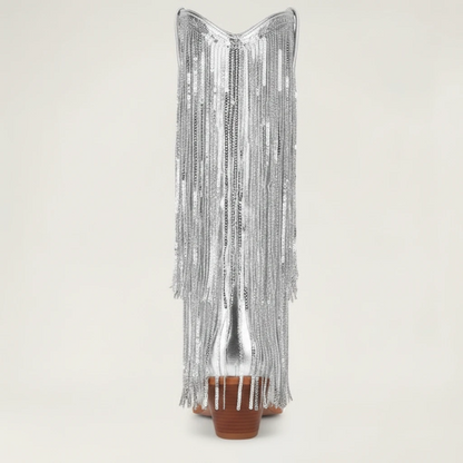 Yehaw silver knee-high vegan leather cowgirl boots with metallic fringe detailing and a pointed toe.