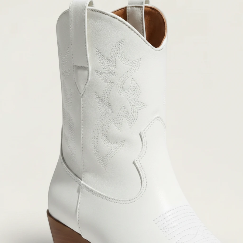 Yehaw CARLA white vegan leather ankle cowgirl boots with pointed toe and medium heel worn by a woman in denim shorts