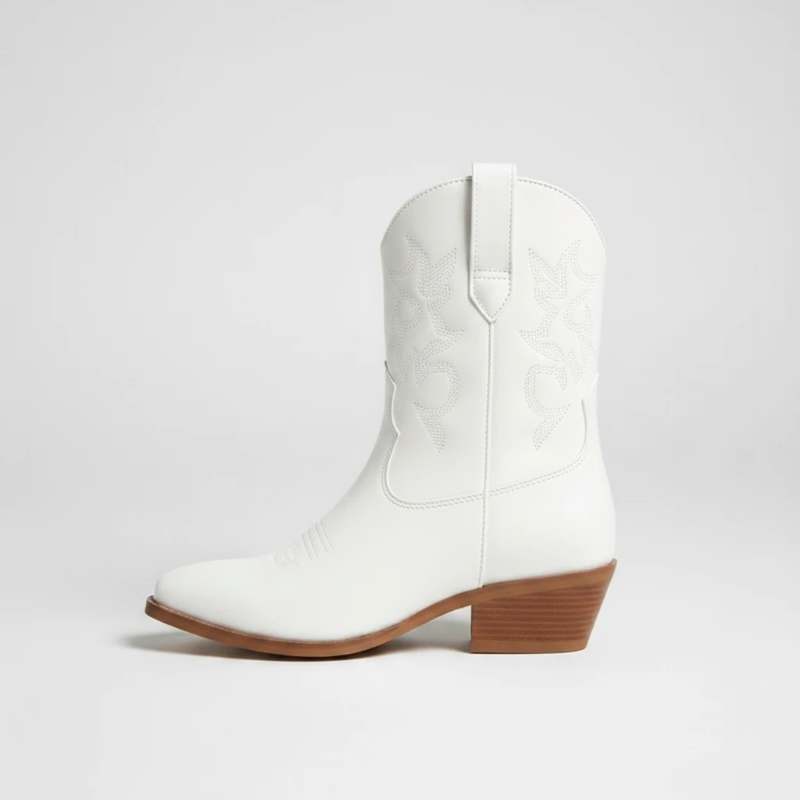 Yehaw CARLA white vegan leather ankle cowgirl boots with pointed toe and medium heel worn by a woman in denim shorts