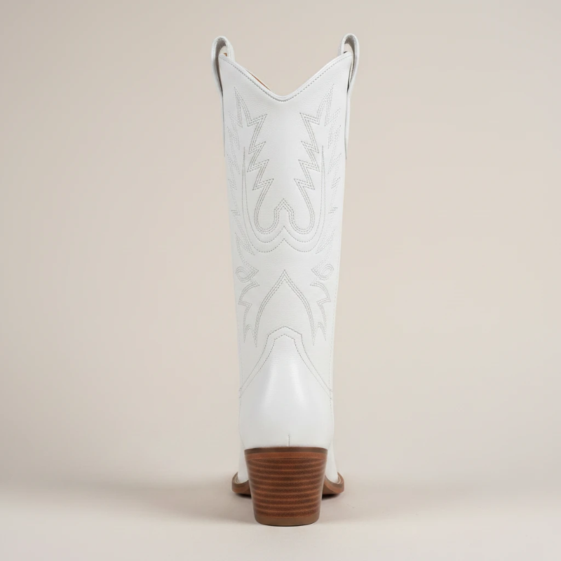 Yehaw white vegan leather mid-calf cowgirl boots with pointed toe and western stitching worn by a woman