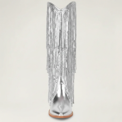 Yehaw silver knee-high vegan leather cowgirl boots with metallic fringe detailing and a pointed toe.