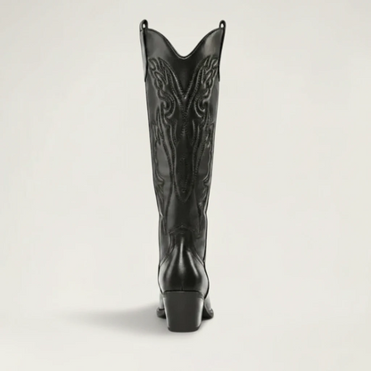 Yehaw black vegan leather knee-high cowboy boots with pointed toe and medium heel. Features intricate western-style stitching.