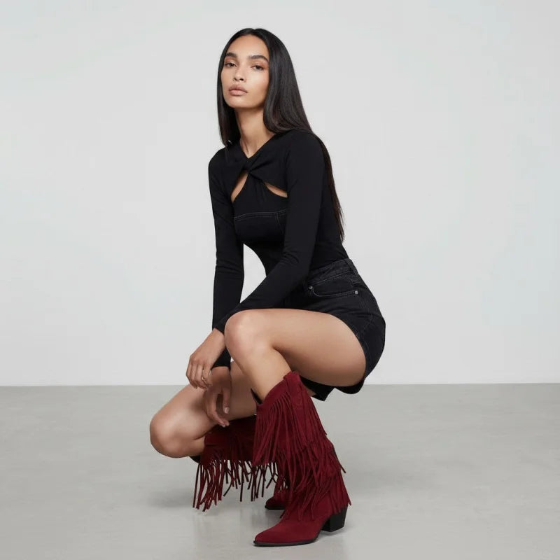 Model wearing Yehaw red vegan suede mid-calf cowgirl boots with fringe detail and pointed toe in a studio setting.