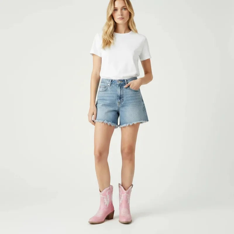 Yehaw pink vegan leather ankle cowboy boots with pointed toe and medium heel, worn by a woman in denim shorts.