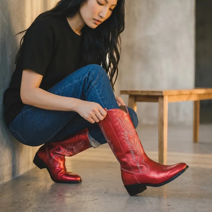 Yehaw red vegan leather mid-calf cowgirl boots with pointed toe and decorative stitching. Woman wearing jeans and black t-shirt.