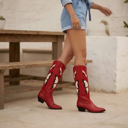 Yehaw Clara red vegan leather mid-calf cowgirl boots with beige butterfly embroidery worn by a woman.