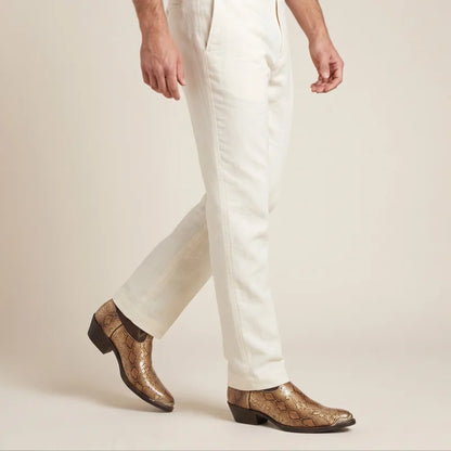 Yehaw golden brown vegan leather cowboy boots with crocodile texture worn by a man in cream trousers