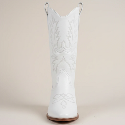 Yehaw white vegan leather mid-calf cowgirl boots with pointed toe and western stitching worn by a woman