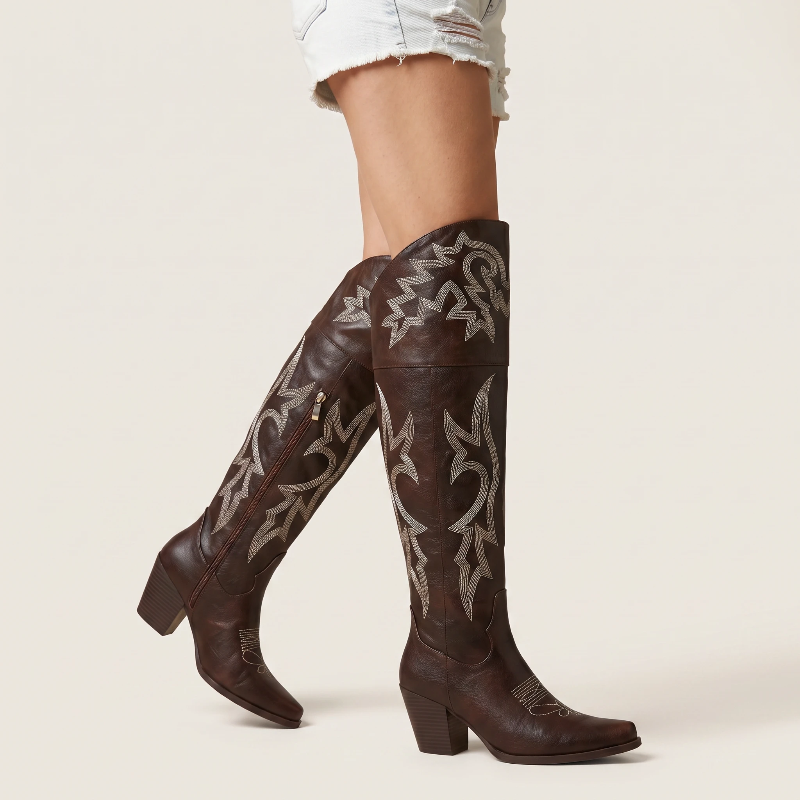 Yehaw brown vegan leather knee-high cowgirl boots with white western embroidery and a pointed toe.