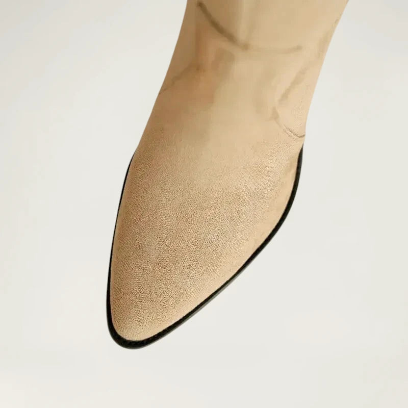 Yehaw beige vegan suede knee-high cowgirl boots with a pointed toe and side zip worn by a woman in denim shorts