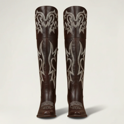 Yehaw brown vegan leather knee-high cowgirl boots with white western embroidery and a pointed toe.