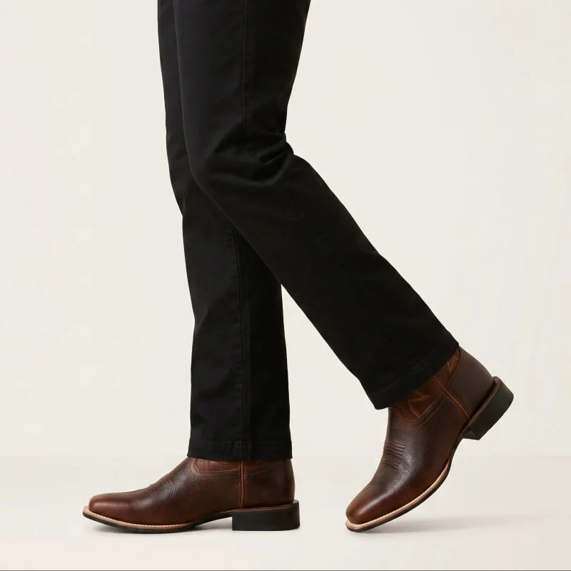 Yehaw brown vegan leather cowboy boots with a round toe and low heel worn by a man in black trousers
