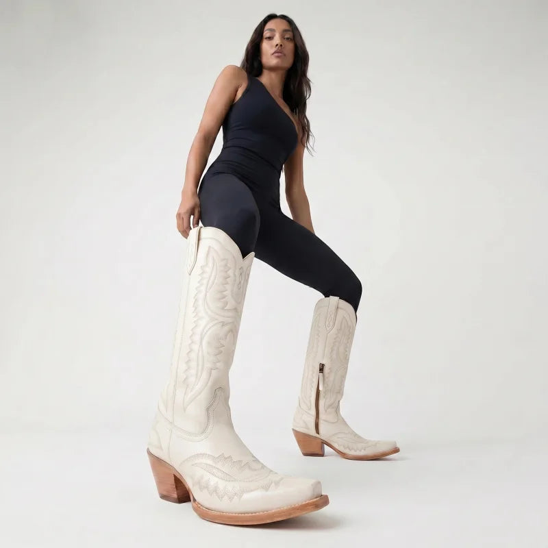 Model wearing Yehaw white knee-high vegan leather cowgirl boots with pointed toe and western stitching